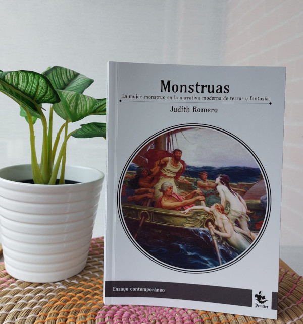 Fotografía de un ejemplar de Monstruas junto a una planta en una maceta